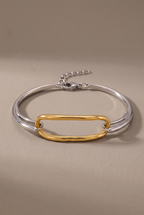 DropIQ two-tone bracelet with a gold oval link on a slim silver band