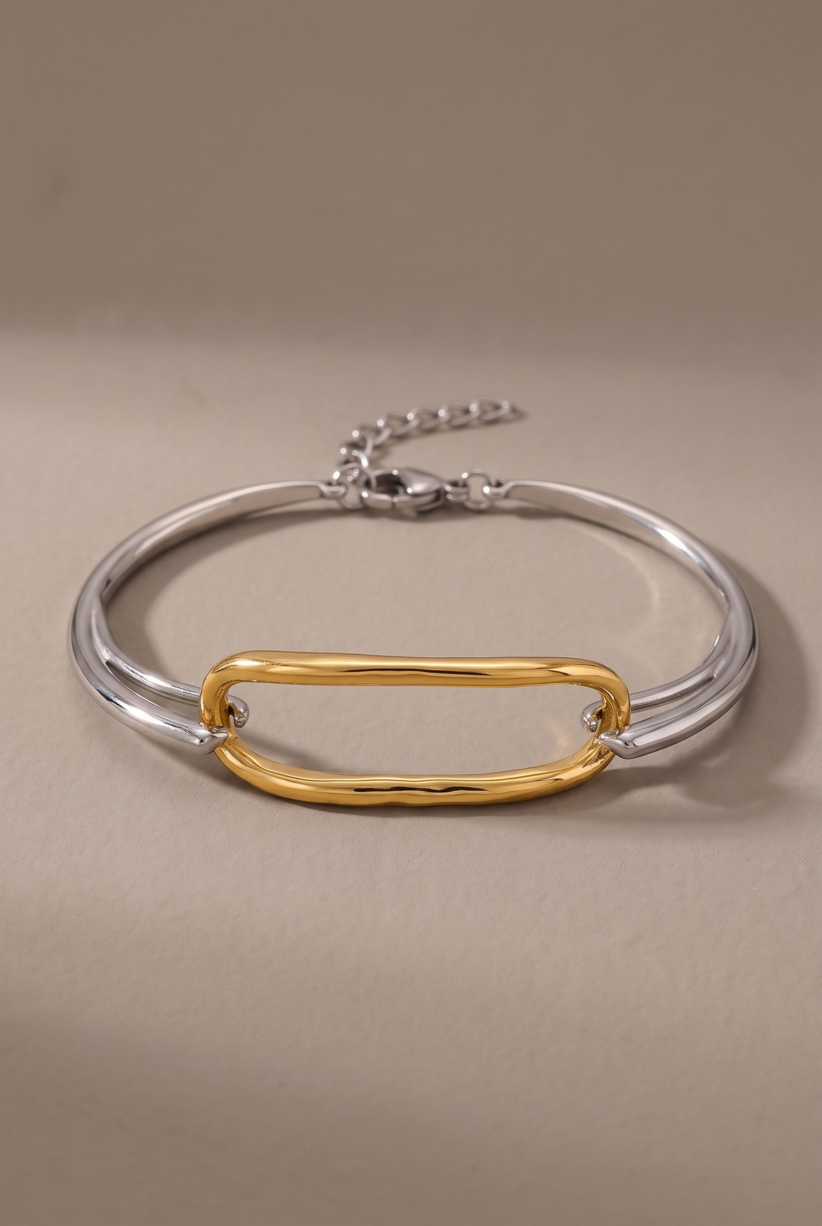 DropIQ two-tone bracelet with a gold oval link on a slim silver band